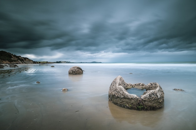 Stunning Sea View with Rocks and Mountains Against a Blue Cloudy Sky – Free Download