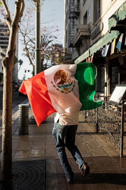 Back View of a Man Holding a Mexican Flag – Free Download