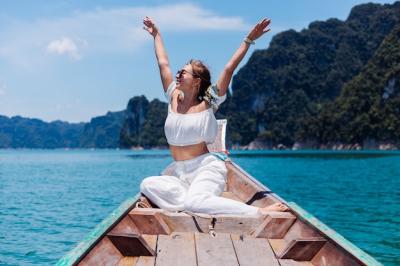 Fashion Portrait of a Young Woman in White Top and Pants on a Thai Wooden Boat in Khao Sok National Park – Free Download