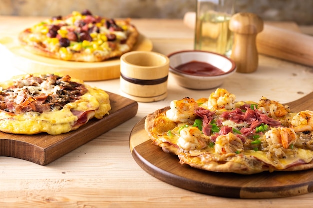 Homemade Traditional Pizzas with Various Toppings on a Wooden Table – Free Download