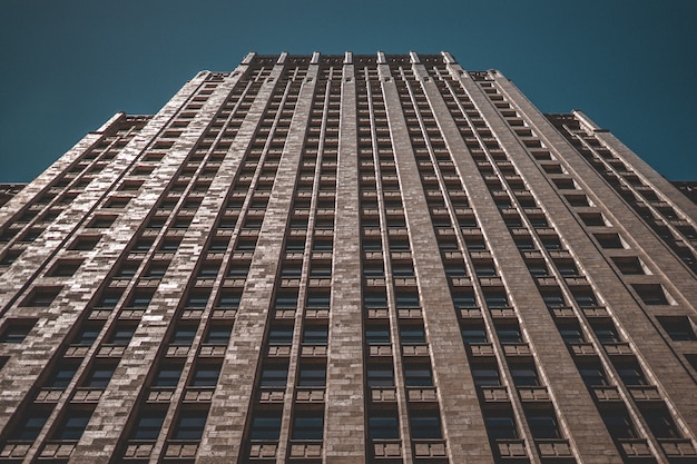 Low Angle Shot of a Tall Business Building Against a Dark Blue Background – Free Download