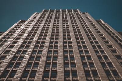 Low Angle Shot of a Tall Business Building Against a Dark Blue Background – Free Download