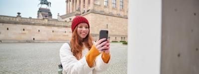 Tourist Girl Smiling While Capturing Historical Landmarks on Smartphone – Free Download