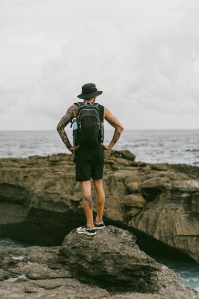 A Young Man Traveler with a Backpack Gazing at the Ocean – Free Download