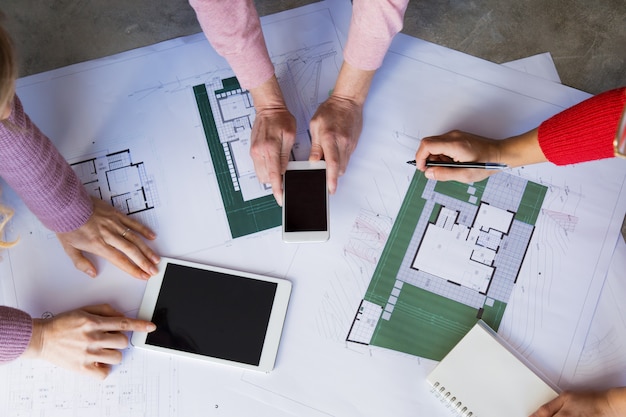 Architects Collaborating on Blueprints at Desk – Free Download