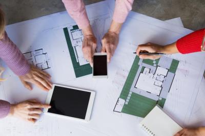 Architects Collaborating on Blueprints at Desk – Free Download