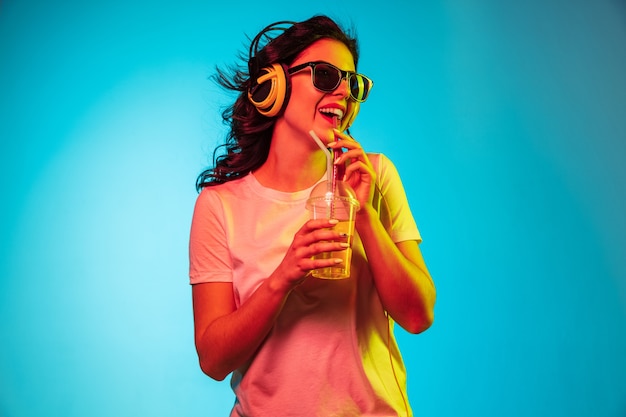 Cheerful Young Woman Smiling Against a Blue Background – Free Download