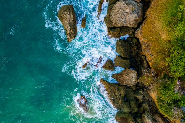 Aerial Shot of Wavy Sea Against Green Cliffs – Free to Download