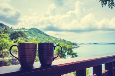 Hot Coffee Cup Against a Beautiful Tropical Outdoor View – Free Download