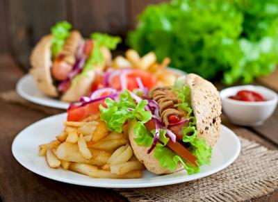 Hotdog with Ketchup, Mustard, and Lettuce on Wooden Table – Free Stock Photo for Download