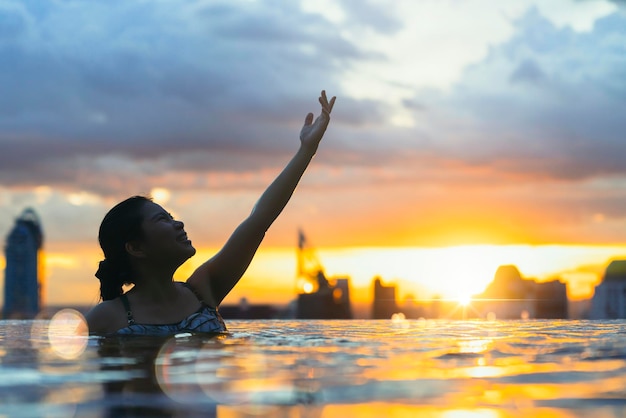 Black Silhouette of Asian Woman Splashing Water in Infinity Pool – Free Stock Photo for Download