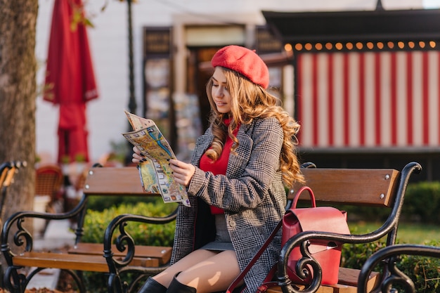 Cute Long-Haired Woman with Curly Hairstyle Exploring a City Map – Free Download