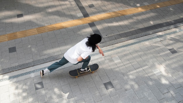 Explore the Thrill of an Asian Man Skateboarding in the City – Free Download