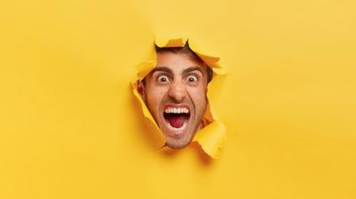 Outraged Man’s Angry Face Through Torn Yellow Paper – Free Stock Photo for Download