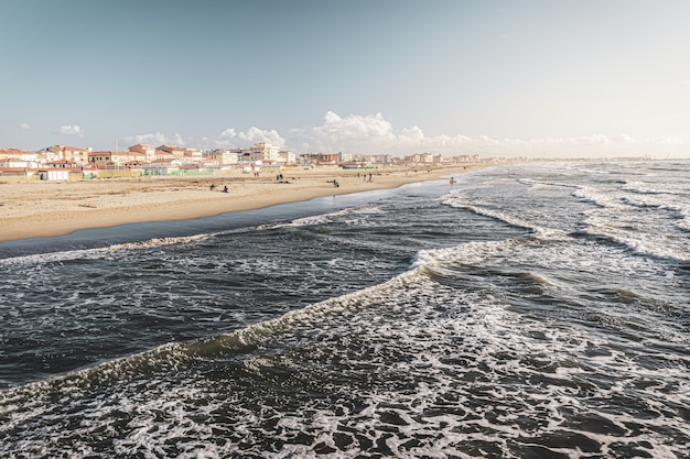 Buildings on the Shore with Dramatic Sea Waves – Free Stock Photo for Download