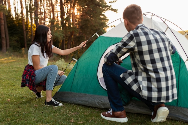 Young Couple Setting Up a Tent in Nature – Free Download