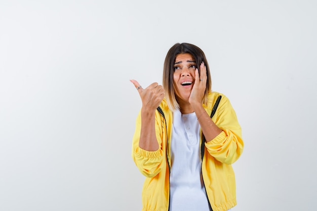 Excited Woman in T-Shirt and Jacket Giving a Thumbs Up â Free Download