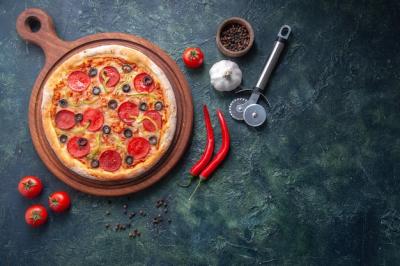 Homemade Pizza with Garlic, Tomatoes, and Peppers on a Wooden Cutting Board – Free Download