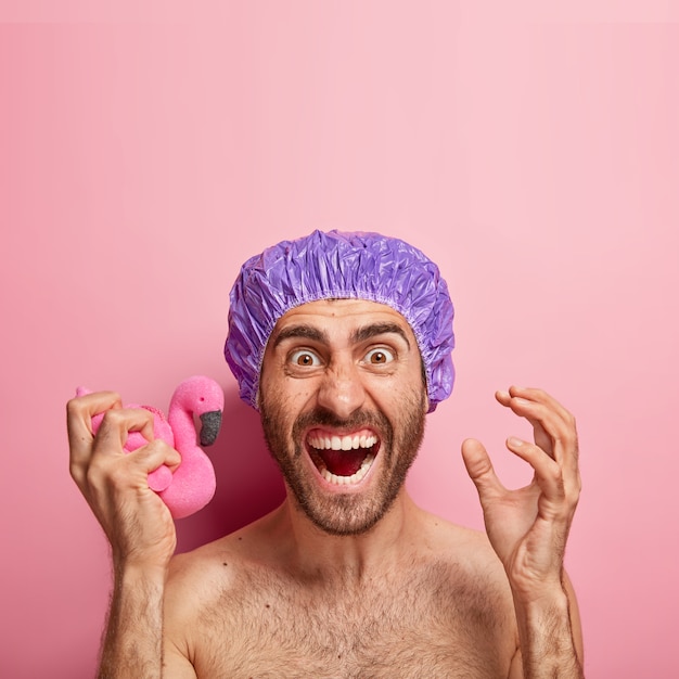 Emotive Man Holding Pink Flamingo Sponge and Shower Cap – Free Stock Photo Download