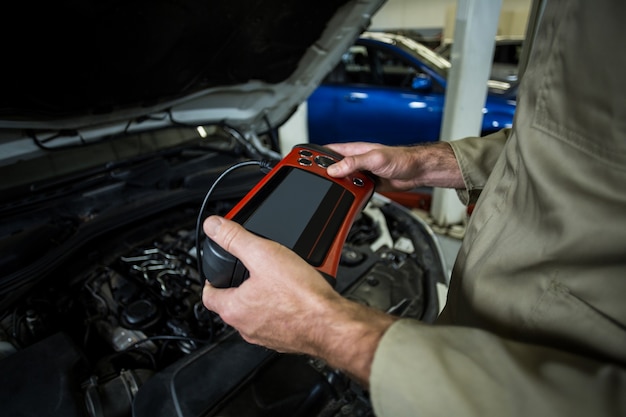 Mechanic Using Diagnostic Tool – Free Download Stock Photo