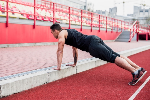 Young Man Doing Pushups on Race Track – Free Stock Photo for Download