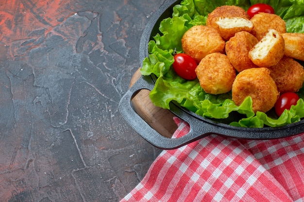 Bottom Half View of Chicken Nuggets with Lettuce and Cherry Tomatoes in Pan