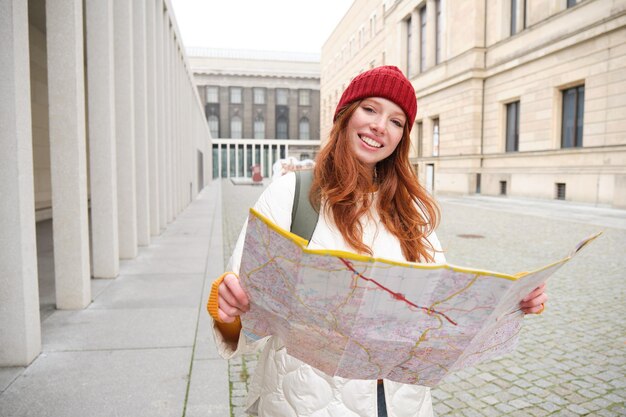 Redhead Girl Tourist Navigating the City with a Paper Map – Free to Download