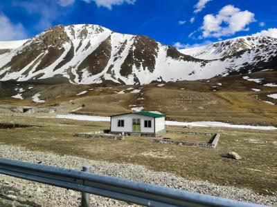 A Small White Building with a Green Roof in Front of a Mountain – Free Download