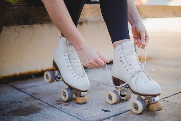 Woman Sitting and Lacing Roller Skates – Free Download