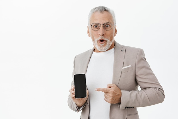 Surprised Businessman Pointing at Smartphone Screen – Free Download