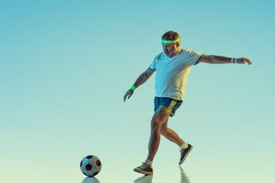 Senior Man Playing Football in Sportwear Under Gradient and Neon Light – Download Free Stock Photo