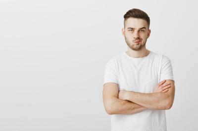 Young Man with Crossed Arms Looking Doubtful – Free Stock Photo for Download