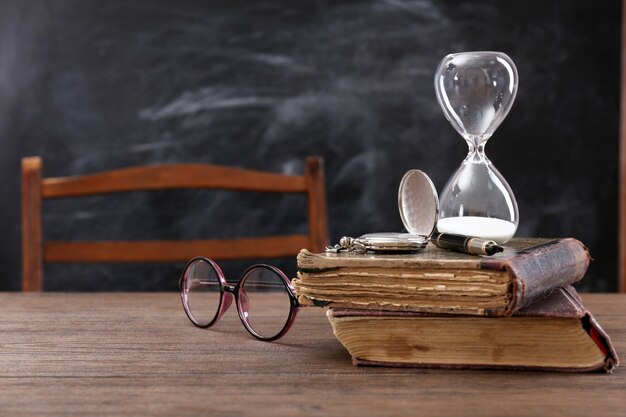 Vintage Composition of Old Books, Eyeglasses, and Hourglass on Wooden Table – Free to Download