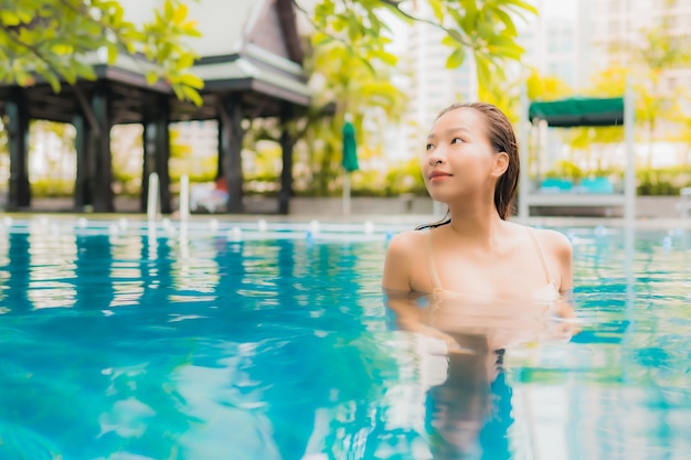 Beautiful Young Asian Woman Relaxing by Outdoor Swimming Pool – Free Download