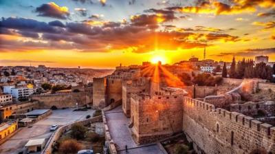 Ancient Stone Castle Silhouetted Against a Vibrant Sunset – Free Download