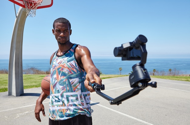 Basketball Player Taking Selfie by the Ocean – Download Free Stock Photo