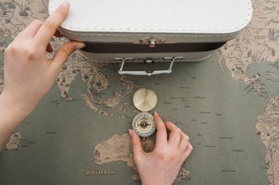 World Map Background Featuring Suitcase and Compass – Free Download