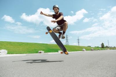 Action-Packed Skateboarding in the City: Young Man Performing Tricks on a Sunny Day – Free Download