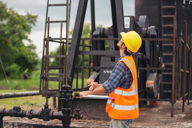 Workers Checking Operations Next to Oil Pumps – Free Download