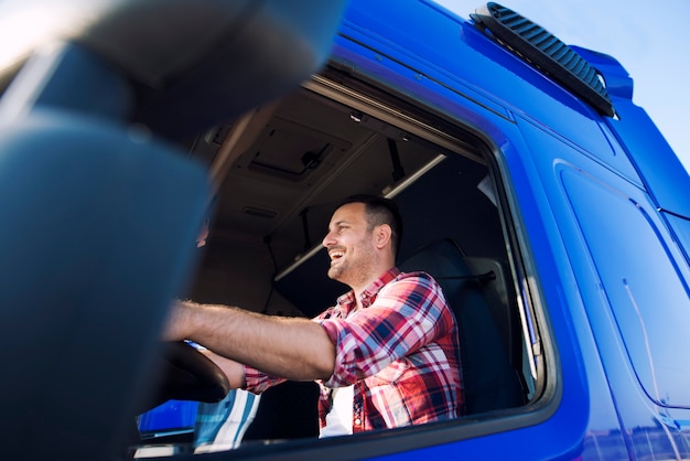 Professional Middle Aged Trucker Driving Truck and Smiling – Free to Download