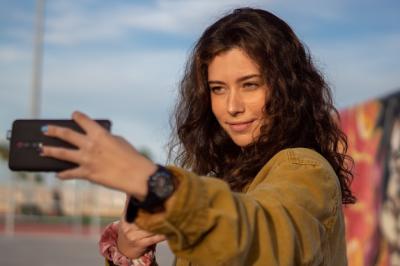 Smiling Girl Taking a Selfie at a Skatepark During the Golden Hour – Free Download