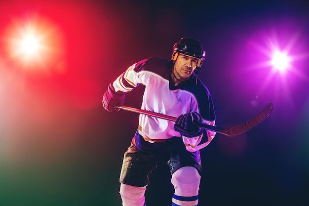 Male Hockey Player Practicing on Ice Court with Dark Neon Wall – Free Stock Photo, Download for Free