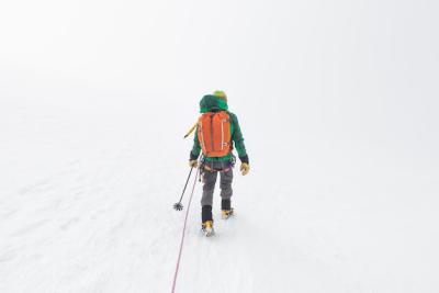 Skier Walking Up a Steep Snowy Slope in the Mountains – Free Download