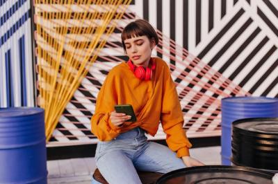 Charming Woman in Orange Outfit with Short Hair – Free Stock Photo for Download