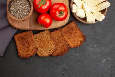 Fresh Tomatoes, Dark Bread Loaves, and White Cheese on Black – Free Download