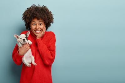 African American Woman in Red Sweater Holding a Dog – Free Stock Photo, Download for Free