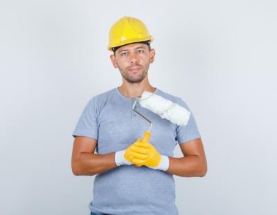 Male Builder in T-Shirt and Helmet Holding Paint Roller – Free Download