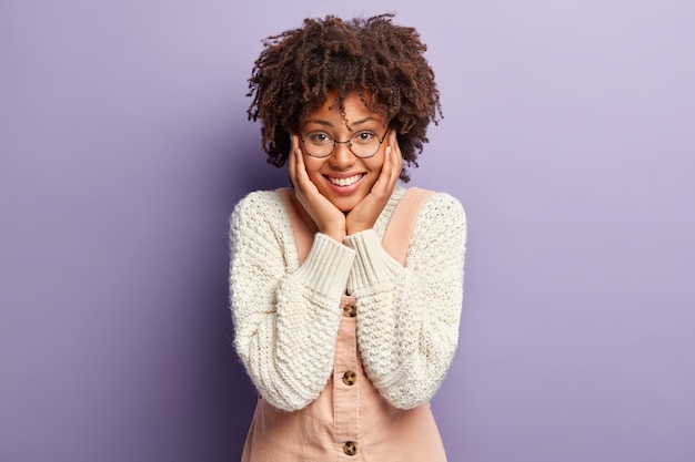 Joyful Moment: Young Woman with Afro Hairstyle Adoring a Child in Knitted Jumper – Free Download