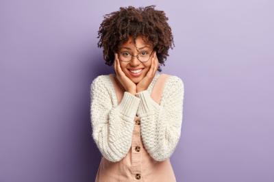 Joyful Moment: Young Woman with Afro Hairstyle Adoring a Child in Knitted Jumper – Free Download