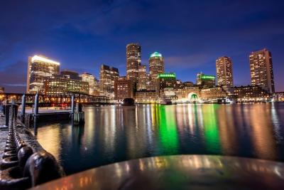 Boston Cityscape at Night: Buildings, Port Reflections, and Starry Blue Sky – Free Download